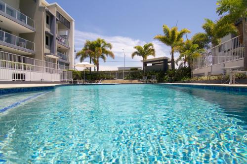 a swimming pool filled with lots of blue water at Splendido Resort Apartments in Gold Coast