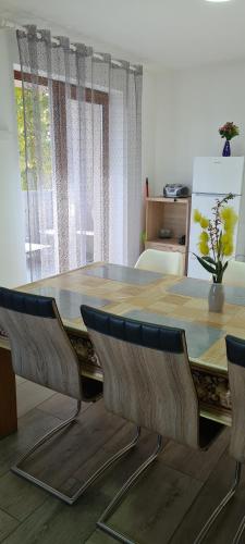 mesa de comedor con sillas y ventana grande en Elena Haus, en Cluj-Napoca