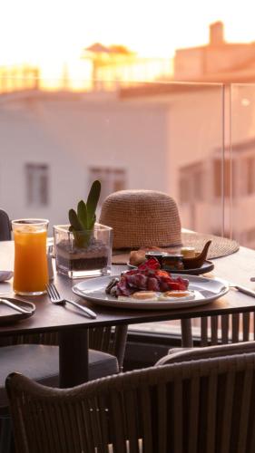 a table with a plate of food and a glass of orange juice at Newkings Boutique Hotel in Cape Town