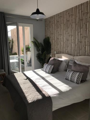 - un grand lit avec des oreillers dans une chambre dans l'établissement Appartement plein centre Saint Florent face au port, à Saint-Florent