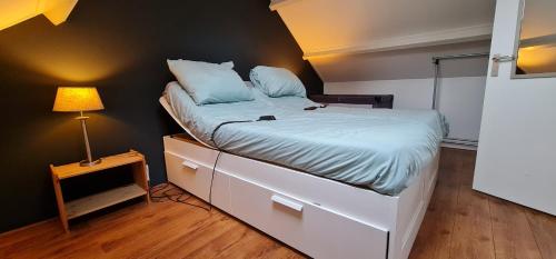 a bedroom with a bed with a night stand and a lamp at Ferienhaus Abenteuer in Egmond aan Zee