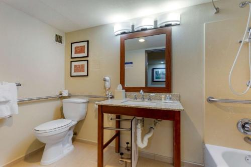 a bathroom with a toilet and a sink and a mirror at Comfort Suites Near Potomac Mills in Woodbridge