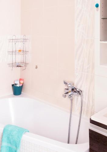 a white bathroom with a tub and a sink at 2-izbový Apartmán Mlynica s balkónom in Mlynica