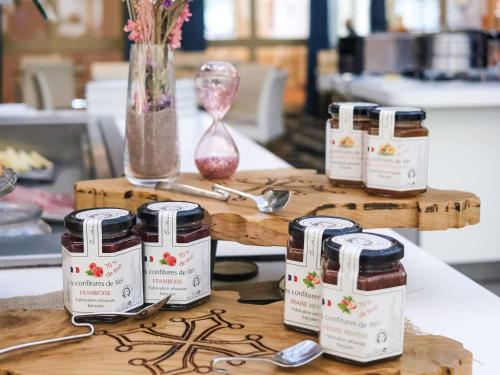 four jars of jam sitting on a table at Mercure Montpellier Centre Antigone in Montpellier