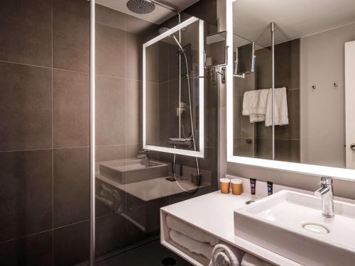 La salle de bains est pourvue d'un lavabo, d'une douche et d'un miroir. dans l'établissement Novotel Orléans Saint Jean de Braye, à Saint-Jean-de-Braye