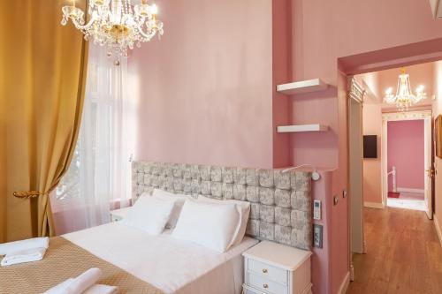 a bedroom with a large bed and a chandelier at Via Villa Iliotti Rhodos in Rhodes Town