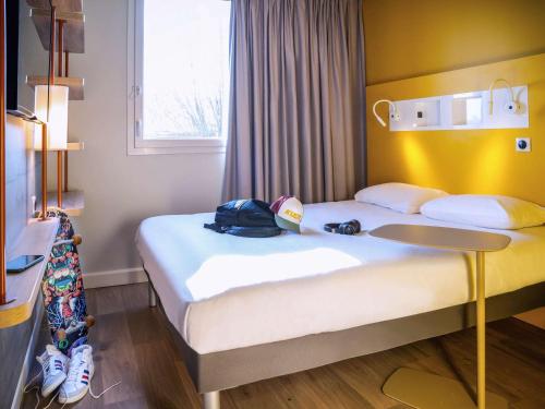 une chambre d'hôtel avec 2 lits avec un sac à dos dans l'établissement ibis budget Reims Parc Des Expositions, à Reims
