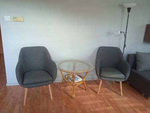 two chairs and a glass table in a room at Słoneczny Apartament w centrum pięknych Karkonoszy in Jelenia Góra