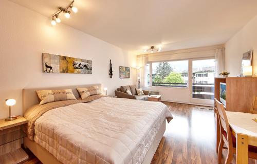 a bedroom with a large bed and a table and a couch at Alpenkette in Garmisch-Partenkirchen