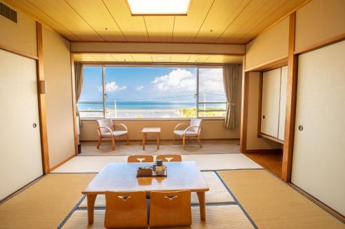 a living room with a table and a view of the ocean at Koran no Yu Kinkouro in Ibusuki