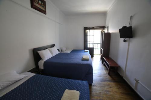 a room with two beds and a television in it at Sumayaq Hostel Cusco in Cusco