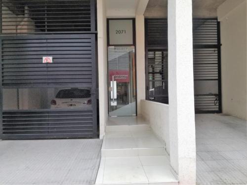 a building with a garage with a car in the window at Apart del Centro 01 in Santa Fe