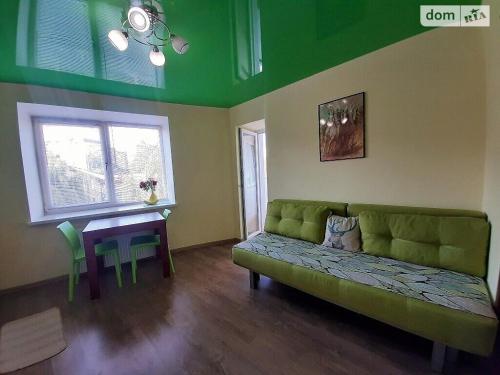 Family and friends apartment في ترنوبل: غرفة معيشة مع أريكة خضراء وطاولة