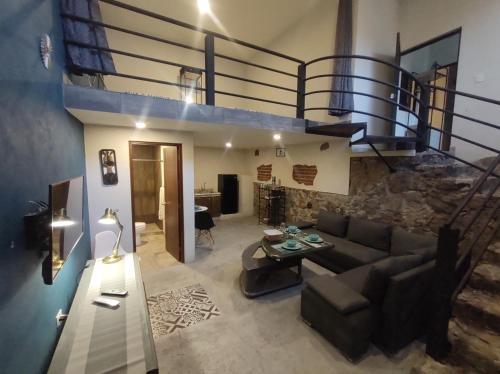 a living room with a couch and a staircase at Casona San Cayetano Suites & Lofts by Lunian in Guanajuato