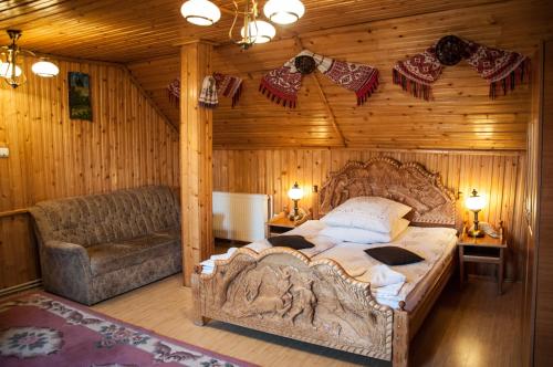- une chambre avec un grand lit et un canapé dans l'établissement Pensiunea Sarmis, à Sarmizegetusa