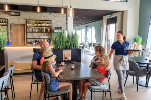 a group of people sitting at a table in a restaurant at RCN Vakantiepark Bungalow de Dukdalf in Kamperland