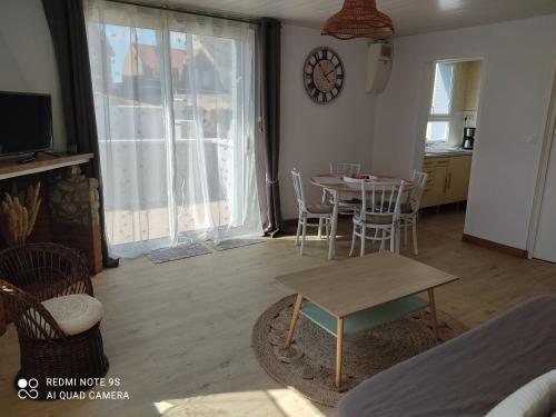 ル・クロトワにあるLe Crotoy plage Baie de somme appartement l'Avocetteのリビングルーム(テーブル、椅子、壁掛け時計付)