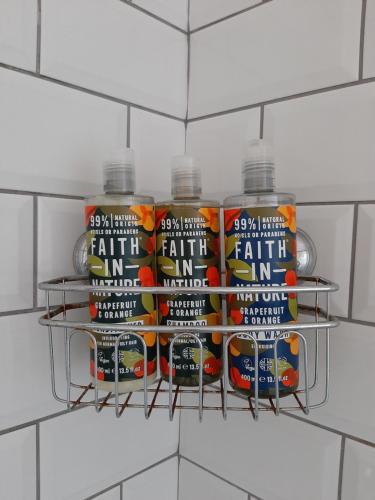 a rack with four bottles of paint on a wall at Home from Home Stay Margate in Margate