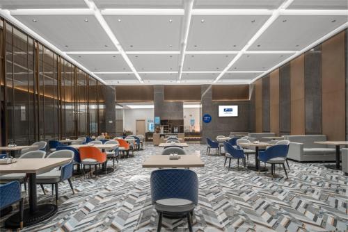a dining area with tables and chairs in a cafeteria at Holiday Inn Express Nanchang Bayi Square by IHG in Nanchang