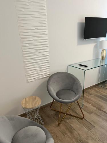 a room with a chair and a desk with a television at IVY PARK in Medolla