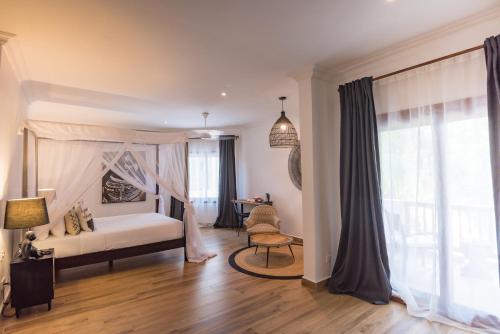 a bedroom with a bed and a desk in a room at Amani Boutique Hotel - Small Luxury Hotels of the World in Paje