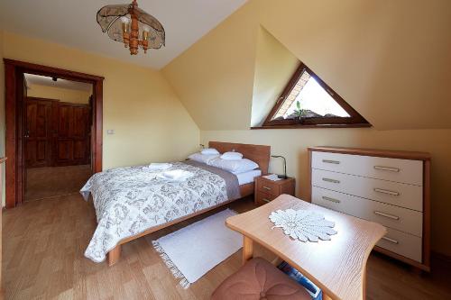 a attic bedroom with a bed and a window at Apartament 1010 m in Ząb
