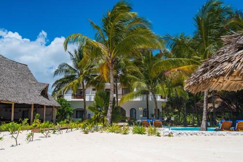a resort on the beach with chairs and palm trees at Amani Boutique Hotel - Small Luxury Hotels of the World in Paje