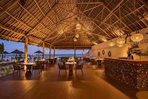 a restaurant on the beach with tables and chairs at Amani Boutique Hotel - Small Luxury Hotels of the World in Paje