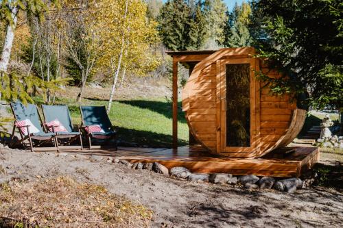 a wooden cabin with a porch and two chairs at Chalupa Lieskovec in Tatranska Strba