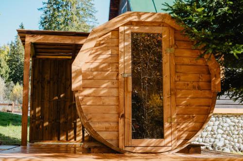 a large wooden outhouse with a door in a yard at Chalupa Lieskovec in Tatranska Strba