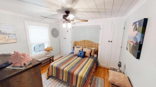 een slaapkamer met een bed en een plafondventilator bij Beach Blossom - Bright, Updated Unit with Hot Tub on Patio in Hilton Head Island