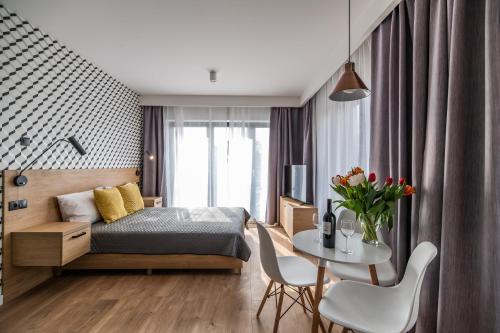 a bedroom with a bed and a table at Krakow Square Residence in Krakow