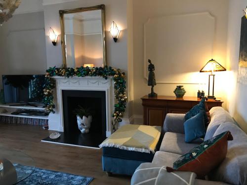 a living room with a couch and a fireplace with a mirror at The Leas View in Folkestone
