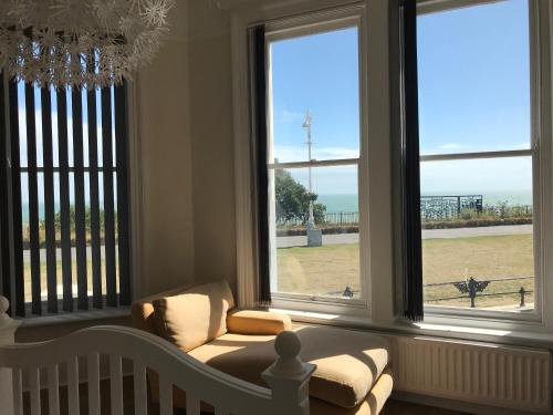 a living room with a couch in front of windows at The Leas View in Folkestone