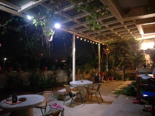 un patio con tavoli e sedie di notte di 豪鵬遊民宿2館 a Jincheng