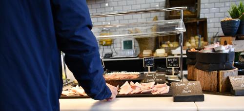 a person standing in front of a counter with meat at Holiday Inn Madrid - Las Tablas by IHG in Madrid