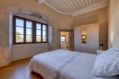 a bedroom with a white bed and a window at Le Domaine du Château in Seynod