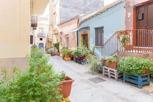 a narrow alley with potted plants and buildings at Casa dell'Aromatario b&b in Sciacca