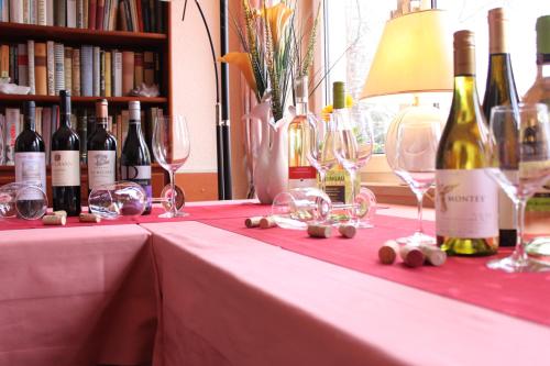 a table with wine glasses and wine bottles on it at Hotel Vinum in Niederwurschnitz