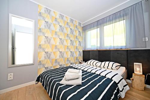 シュチルクにあるSzczyrk Apartament Miętowy z balkonem - Słoneczna Góraのベッドルーム(黒と白のストライプのベッド1台付)