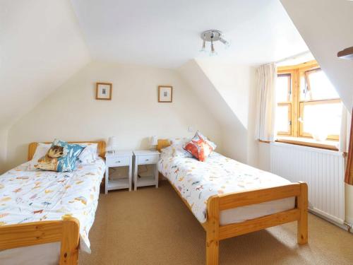 1 dormitorio con 2 camas y ventana en Milne's Brae, cosy, comfortable and centrally located in beautiful Braemar en Braemar