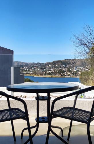 Una mesa y sillas en un balcón con vista al mar. en Domus Lake Resorts, en Villa Carlos Paz