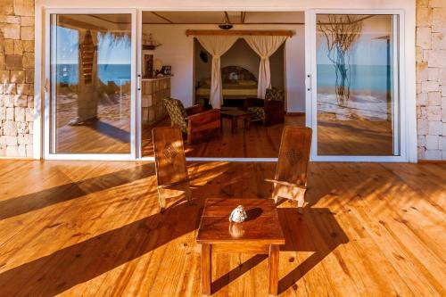 a living room with a table and chairs on a wooden floor at Ankasy Lodge in Tsifota