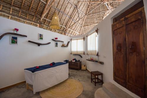 a room with a table and a large ceiling at Amani Boutique Hotel - Small Luxury Hotels of the World in Paje
