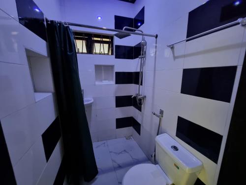 La salle de bains est pourvue de toilettes et d'un lavabo. dans l'établissement CG Apartments, à Ikeja