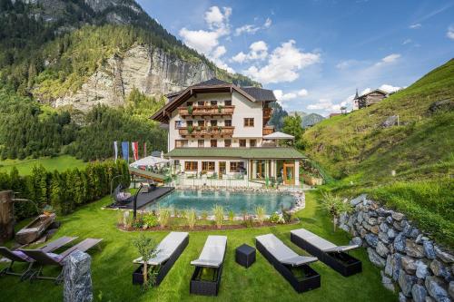 um hotel numa colina com piscina em Natur- & Auszeithotel Hüttenwirt em Hüttschlag