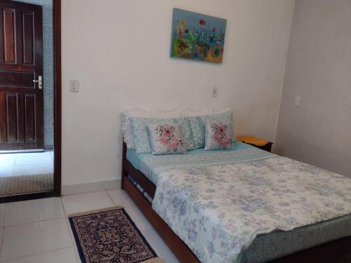 een kleine slaapkamer met een bed en een spiegel bij Apartamentos de Férias por Temporada Martim De Sá in Caraguatatuba