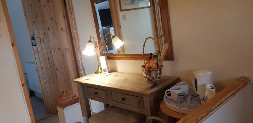 a bathroom with a wooden vanity with a mirror at The Old Sun private cottage in Frome