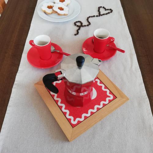 a table with a coffee maker and two cups on it at A cà rèste in Capizzone