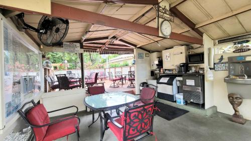 a dining room with a table and chairs and a kitchen at Barefoot mailman motel in Lantana